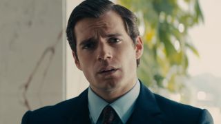 Henry Cavill looks curious while wearing a dark blue suit in The Man From U.N.C.L.E.