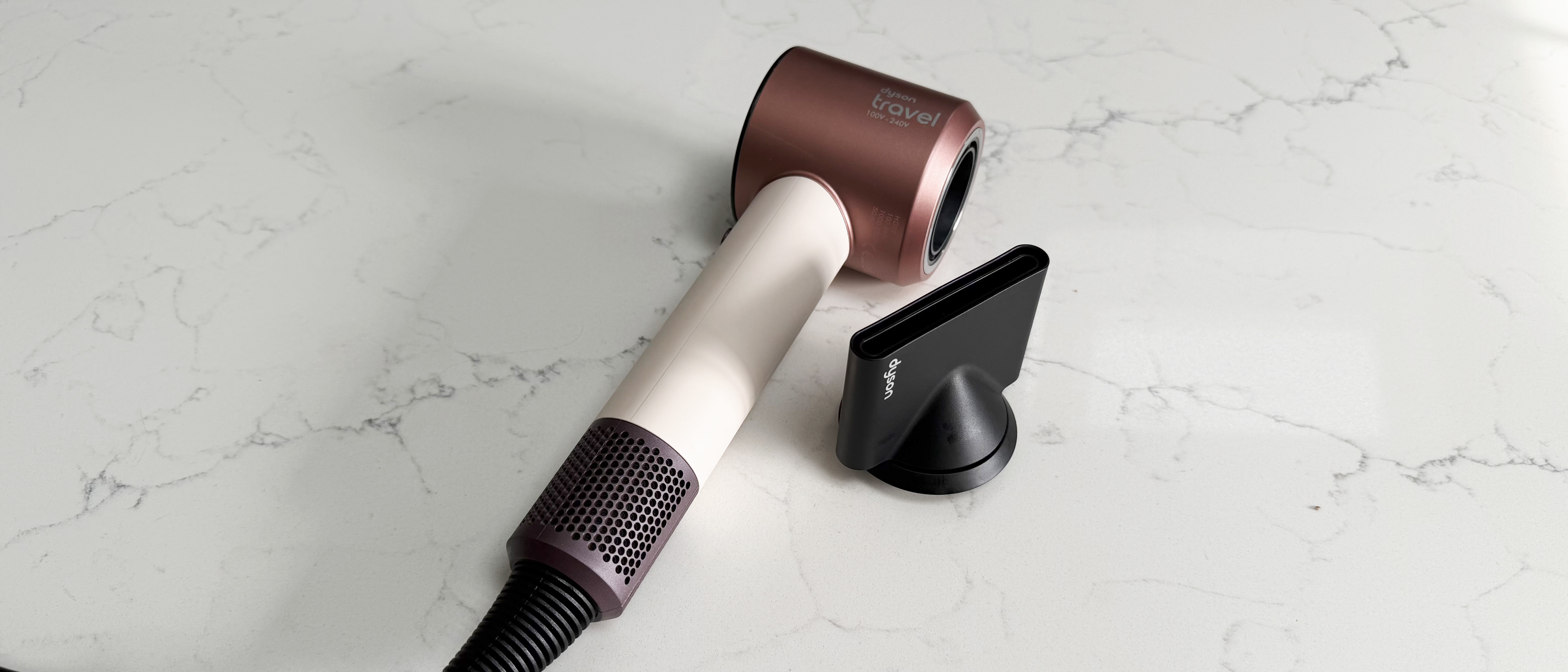 Dyson Supersonic Travel hair dryer alongside the smoothing nozzle attachment