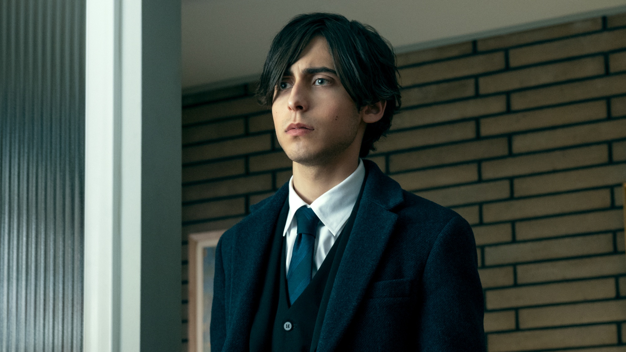 Aidan Gallagher as Number Five in a suit and tie in The Umbrella Academy
