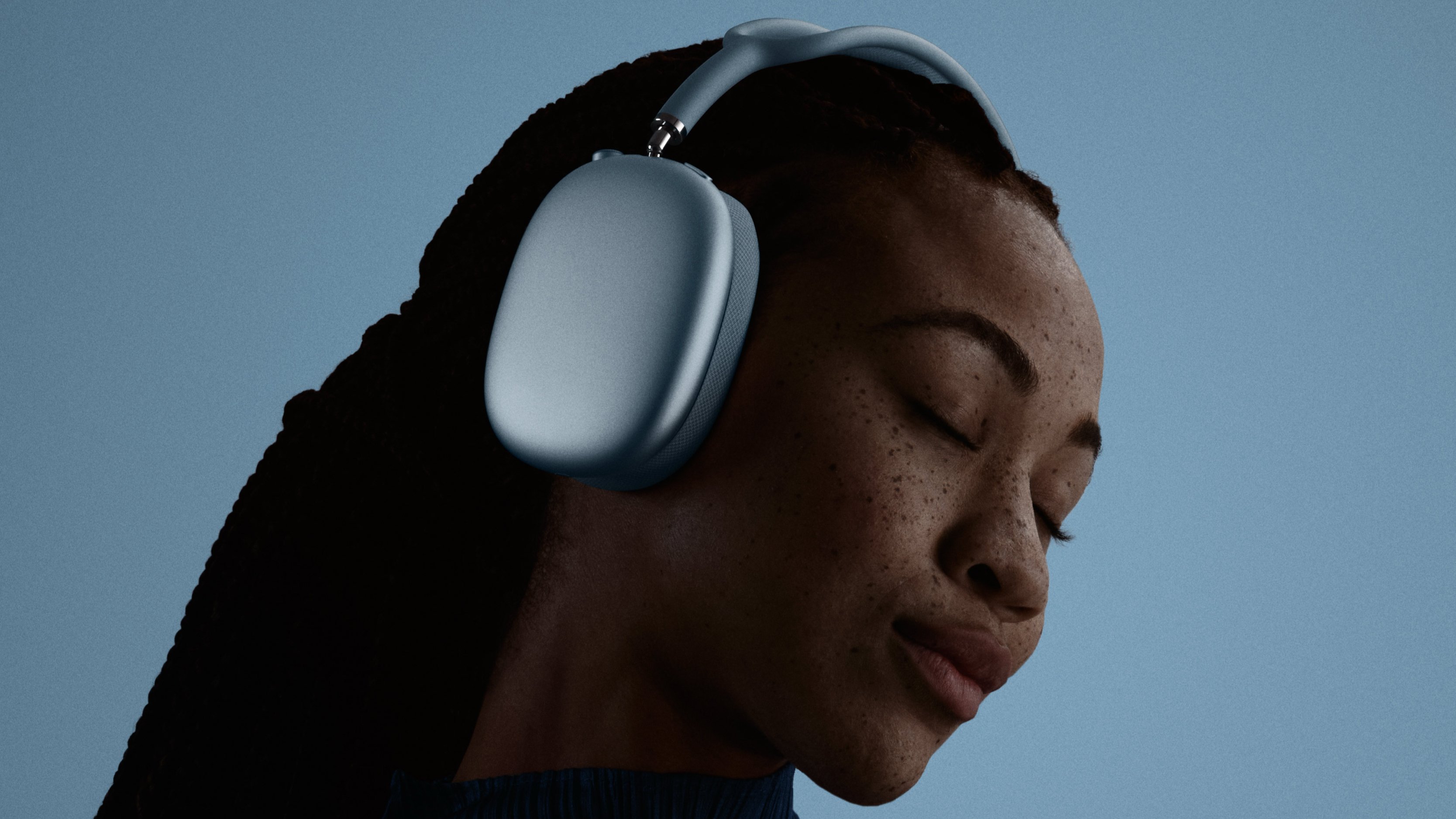 A woman wearing AirPods Max 2 in blue