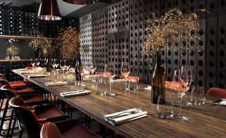 Wine glasses and folk spoon on wooden table at Margaux, London