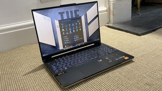 Asus TUF A16 laptop open on a beige rug