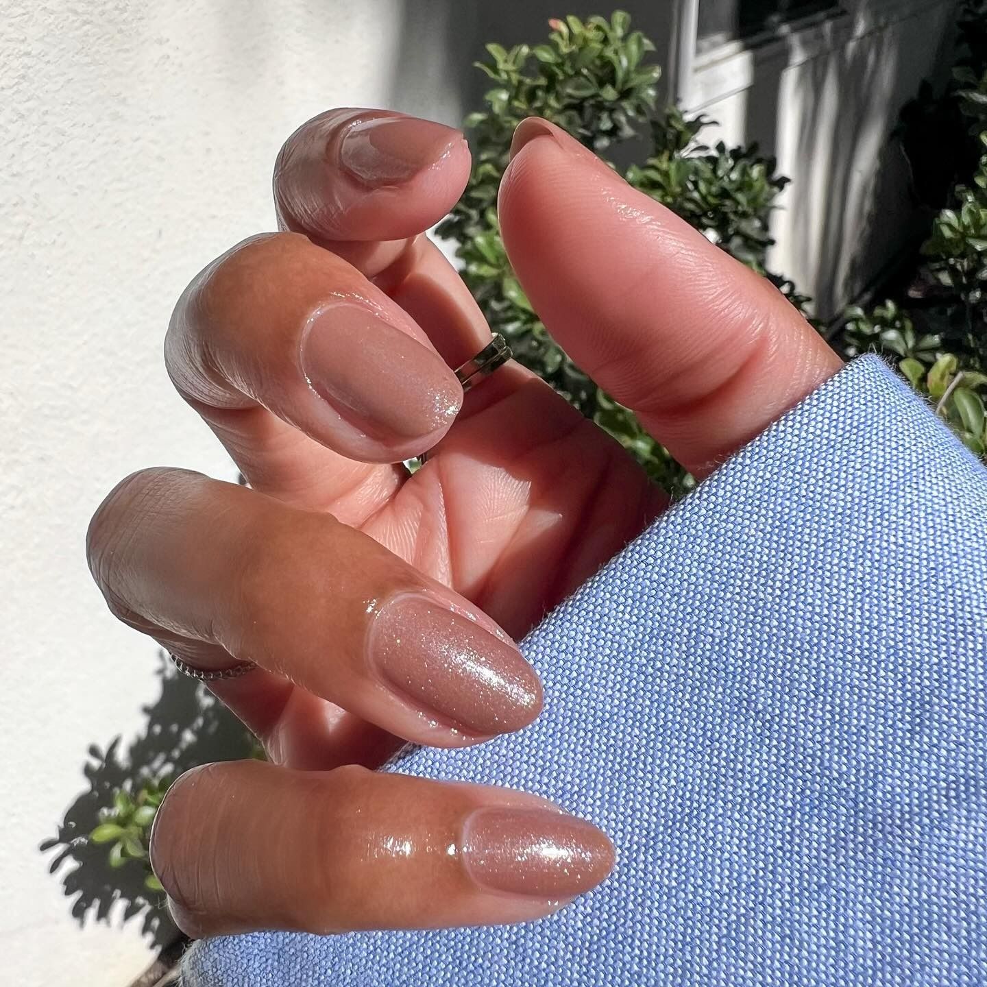 A close-up shot of a brown manicure with a shimmery finish