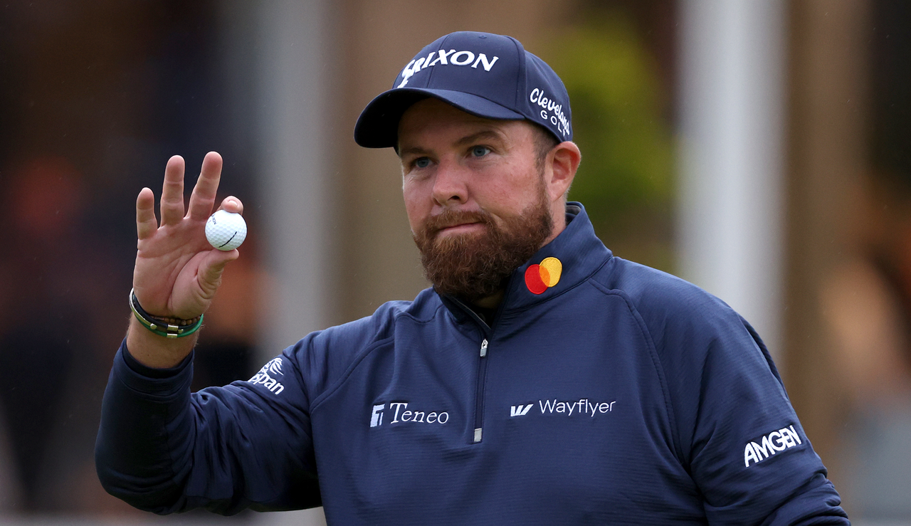 Shane Lowry waves to the crowd after holing a putt on the 18th green