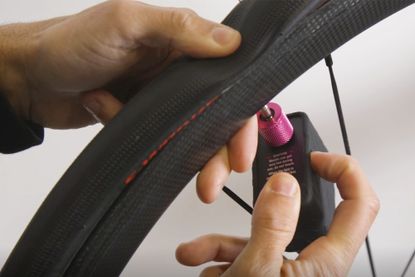 Cycling Weekly Video Manager Sam using the Muc-off Airmach electric bike pump to inflate a flat bike tyre
