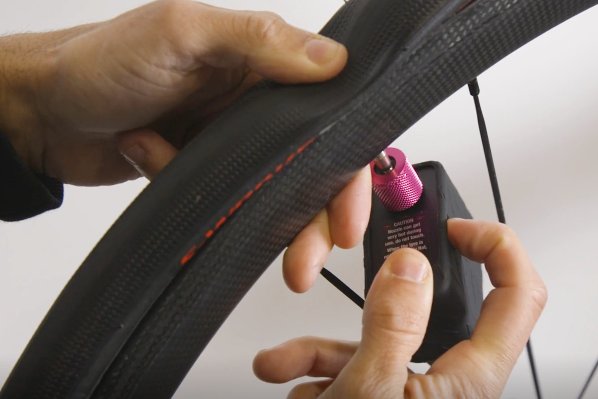 Cycling Weekly Video Manager Sam using the Muc-off Airmach electric bike pump to inflate a flat bike tyre