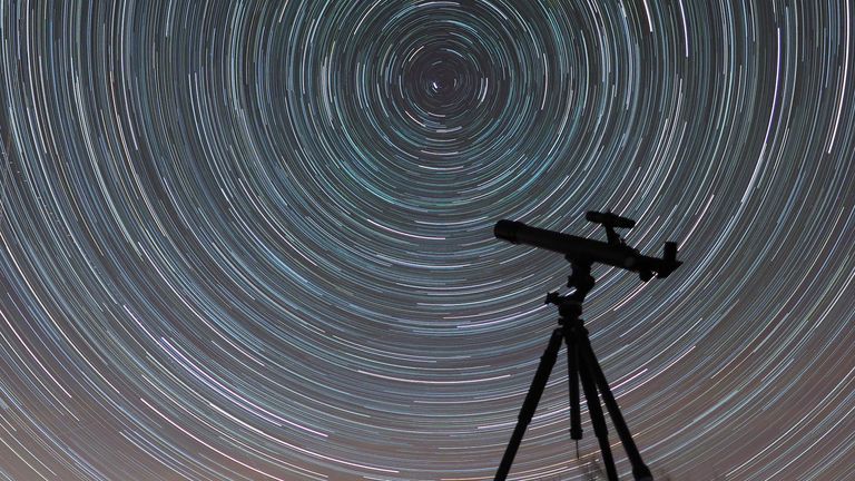 A time-lapse photograph of a telescope against a starry sky