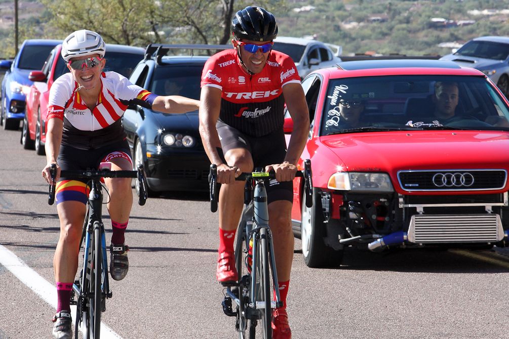 A camp guest jokes with Alberto Contador as they make their way up Mt. Lemmon