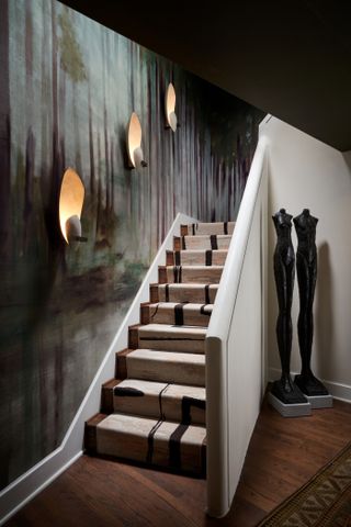 A staircase with lighting sconces