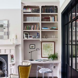 Neutral living room with alcove by fireplace with desk and shelving