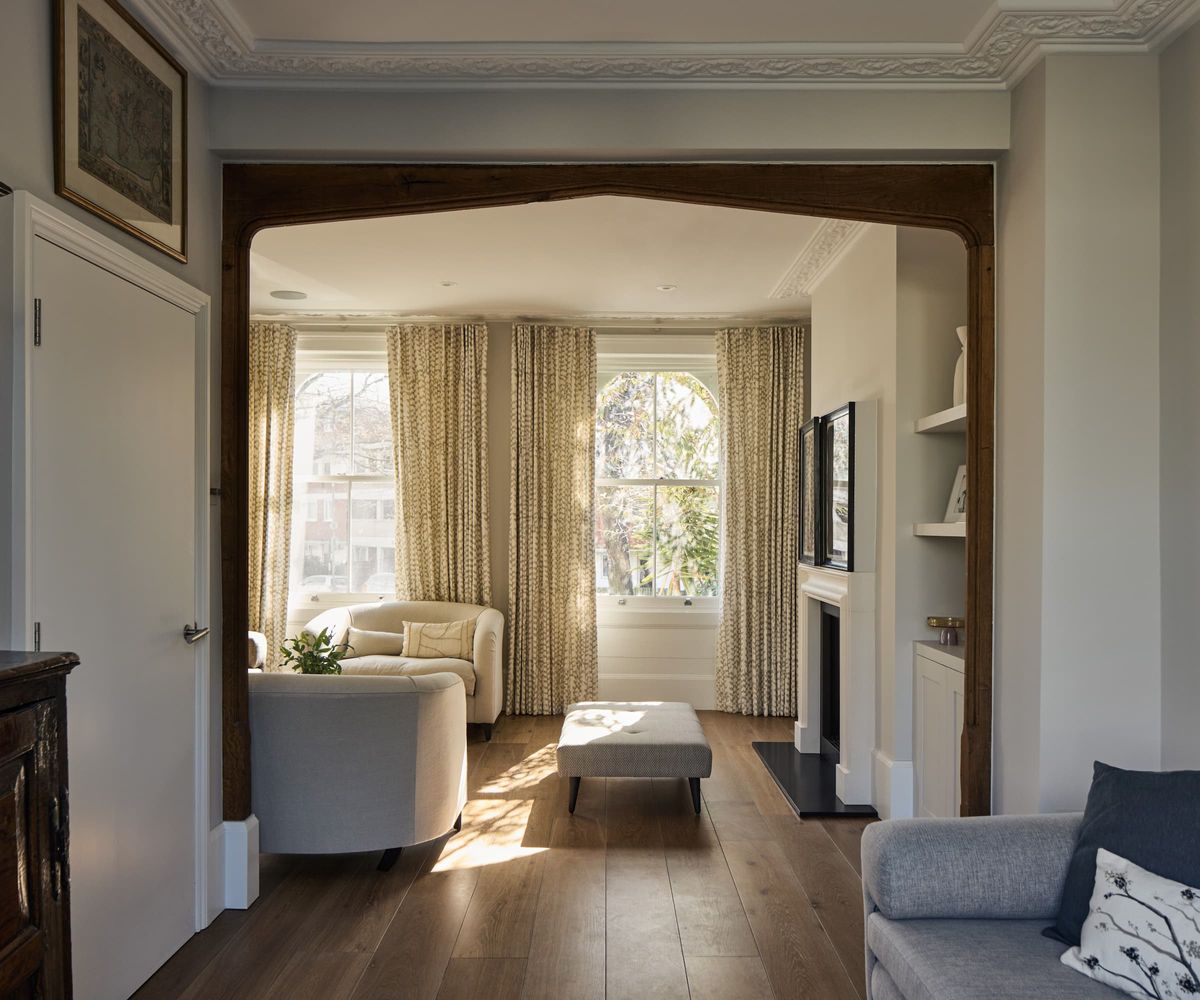 A living room with wooden panel flooring and three sofas