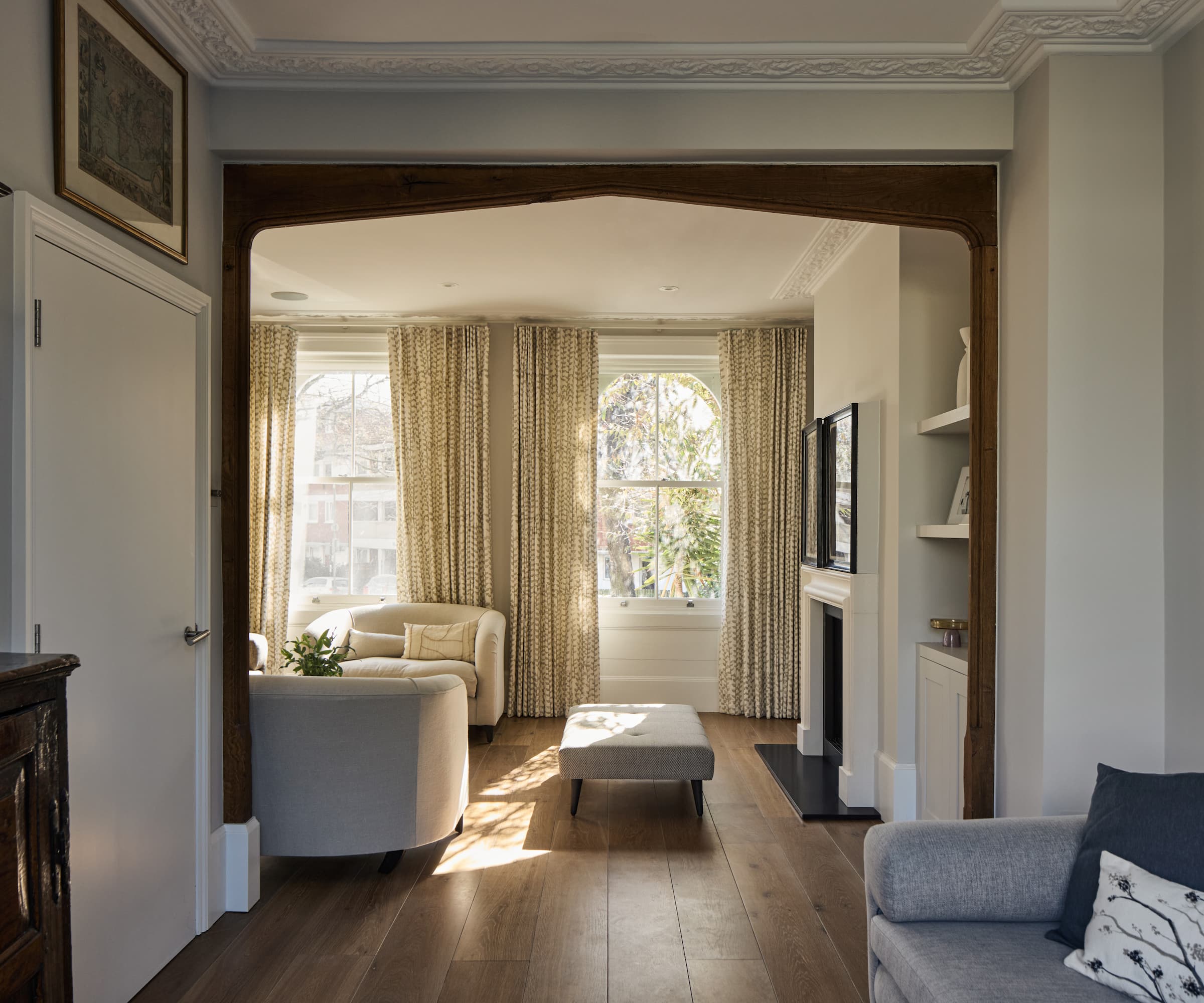 A living room with wooden panel flooring and three sofas
