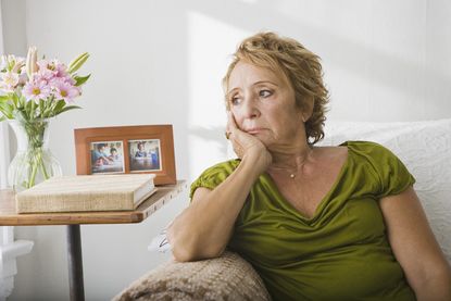 Woman sitting on a sofa with head resting on her hand