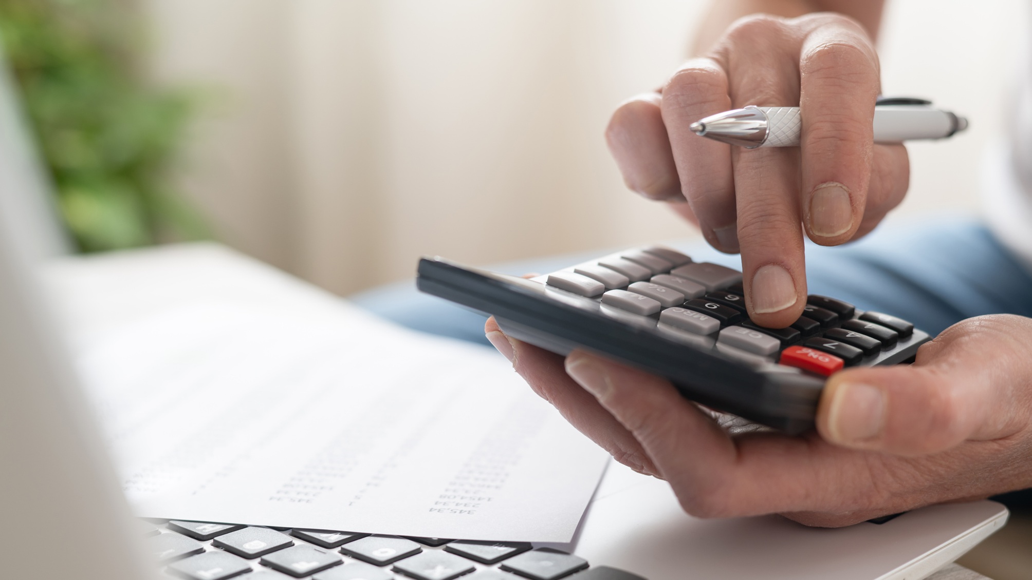 A man uses a calculator, only his hands showing.