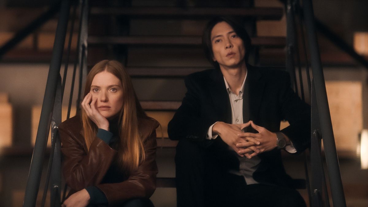 Camille and Issei sit on stairs as they look at something off camera in Drops of God.