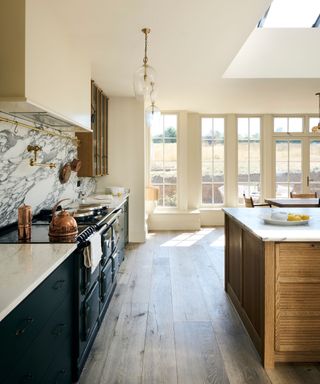 A run on dark blue lower kitchen cabinets with a traditional range cooker and a wooden island