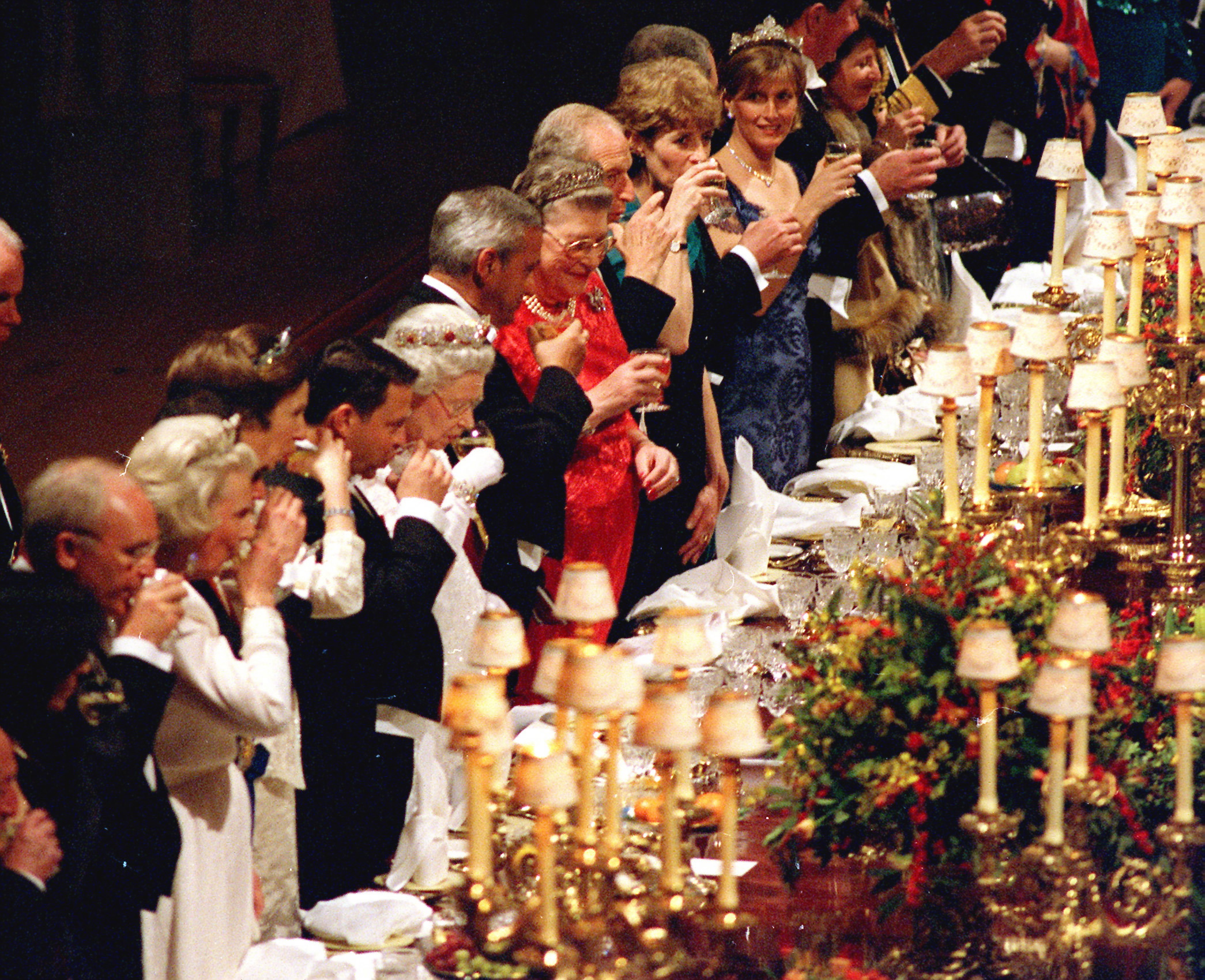 Queen Elizabeth, Duchess Sophie and other guests standing up drinking a toast at a state banquet in 2001