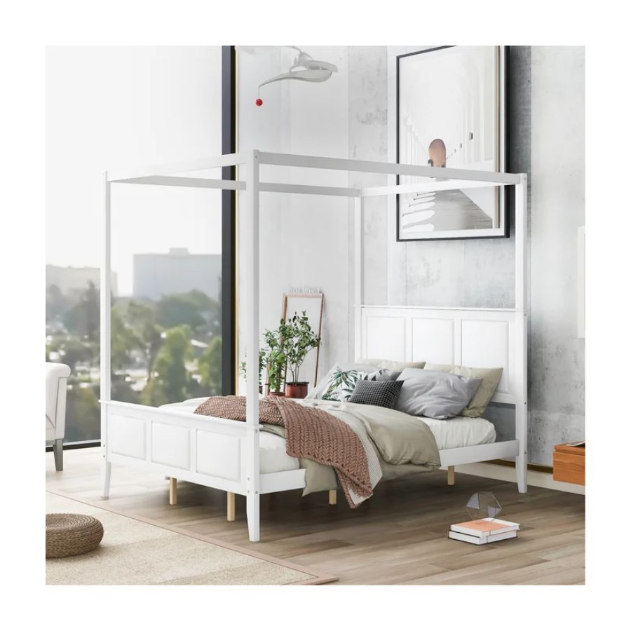 white four poster bed in bedroom with large window