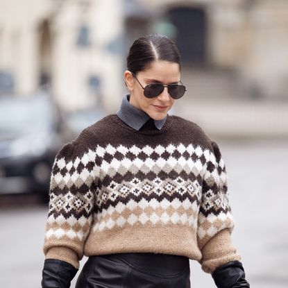 How Pollution Affects Skin Gili Biegun wears maxi leather skirt, large Demellier London The Stockholm bag, brown Nordic holiday sweater, large brown fur scarf and black leather gloves on December 06, 2025 in Copenhagen, Denmark