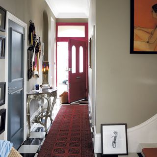 hallway with red carpet and wall painting
