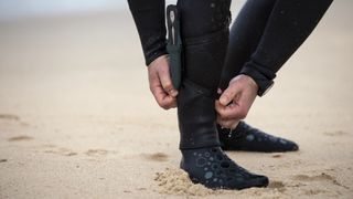 Free diver aligning ankle wetsuit panels