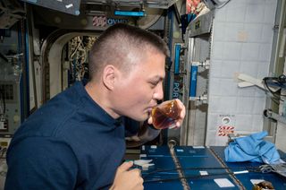 NASA astronaut Kjell Lindgren is seen sipping from a Spaceware (IRPI) Space Cup aboard the International Space Station.