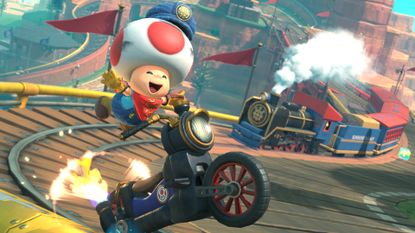 Best Switch 2 games: Toad smiling while racing on a train track during Mario Kart World. 