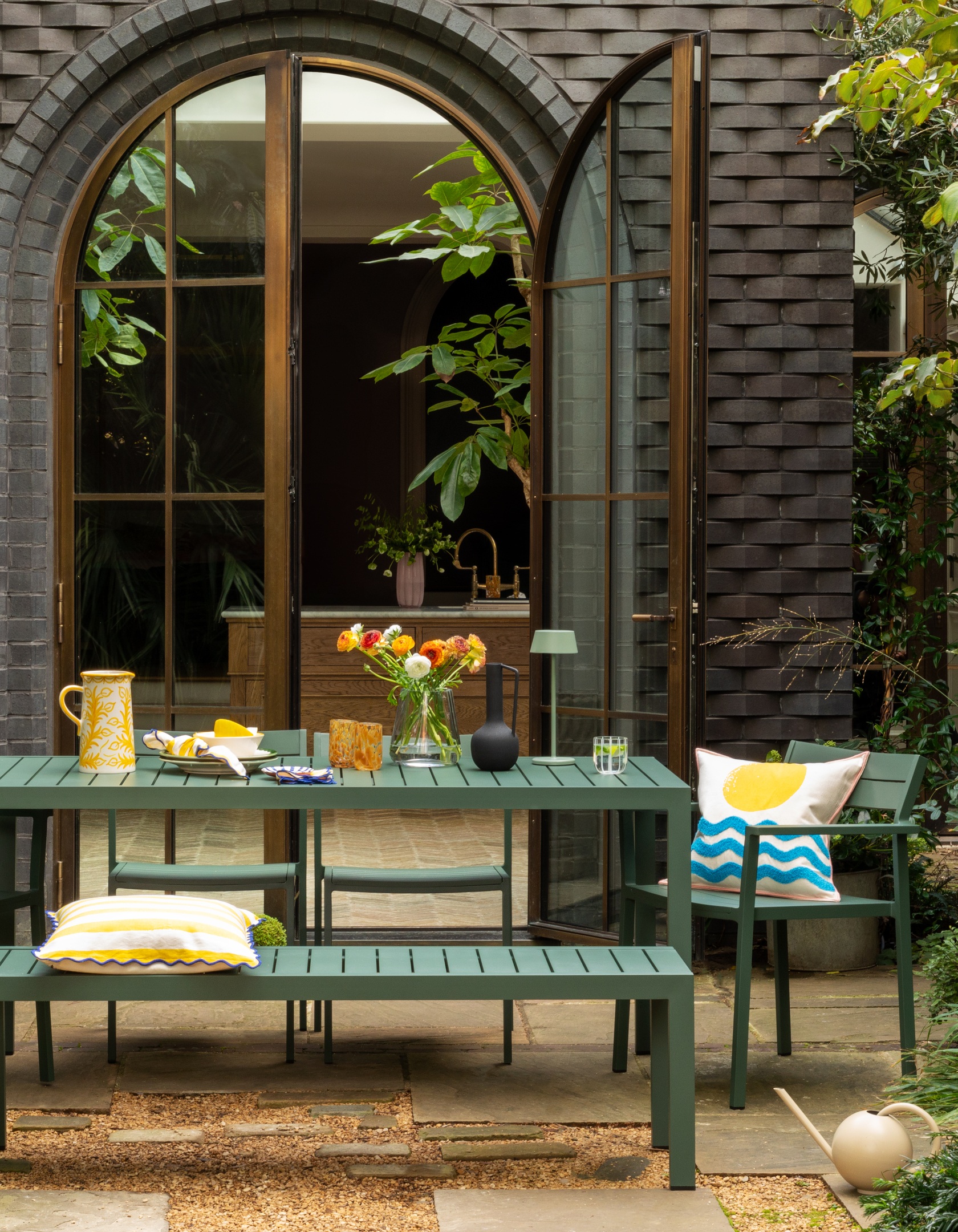 green outdoor table on patio in front of arched patio doors