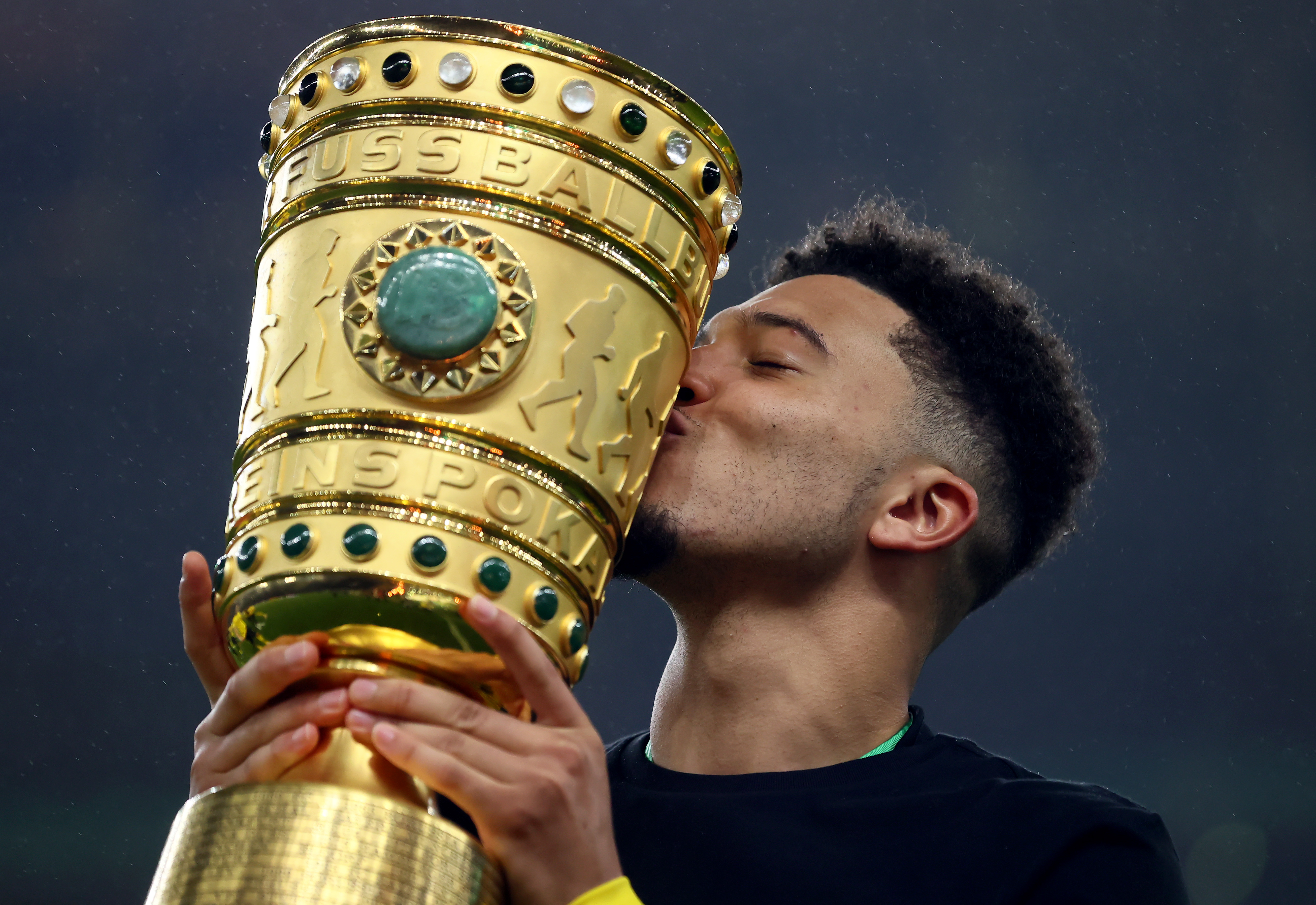 Jadon Sancho kisses the DFB-Pokal trophy after Borussia Dortmund's win over RB Leipzig in the final in May 2021.