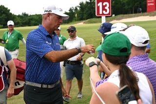 Stewart Cink hands his golf ball to a fan after a hole-in-one