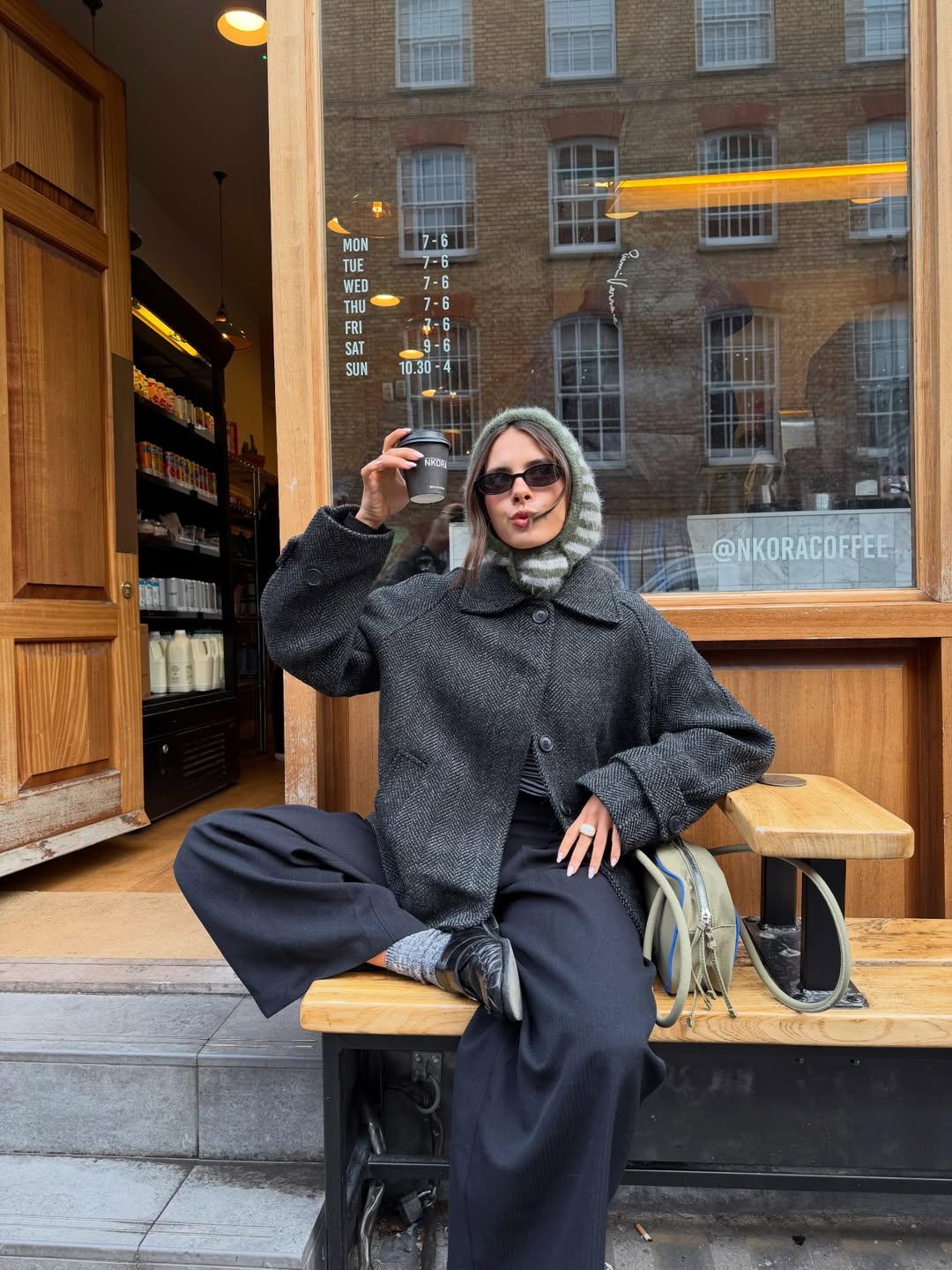 @tia_dewitt wears navy trousers, grey coat and loafers