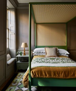 green painted four poster bed with yellow canopy fabric