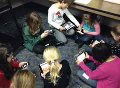 Fourth-grade students at Mason Elementary engage in reading activities on their devices. 