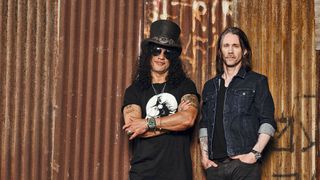 Slash and Myles Kennedy standing in front of a corrugated iron shed