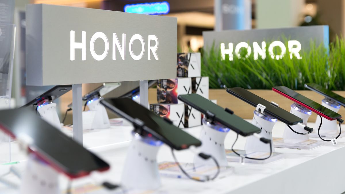 Honor smartphones shown on a retail display in an electronic store with the brand&amp;#039;s logo in the background.