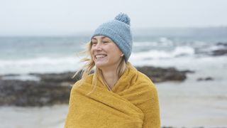 Woman wrapping up warm after wild swimming
