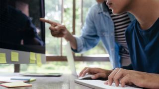 man and woman working together on iMac