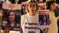 A woman holds placards identifying one of the Israeli hostages held by Palestinian militants 