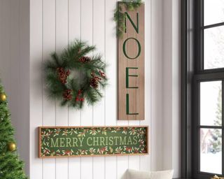 Christmas wreath on wall with Christmas signs