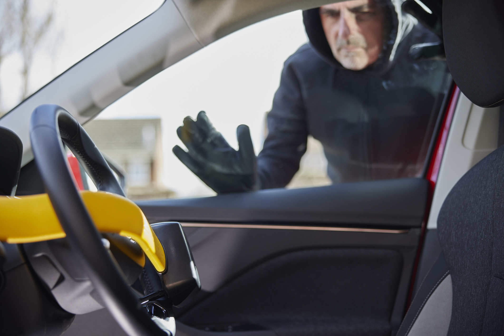 a car thief examining a steering wheel lock