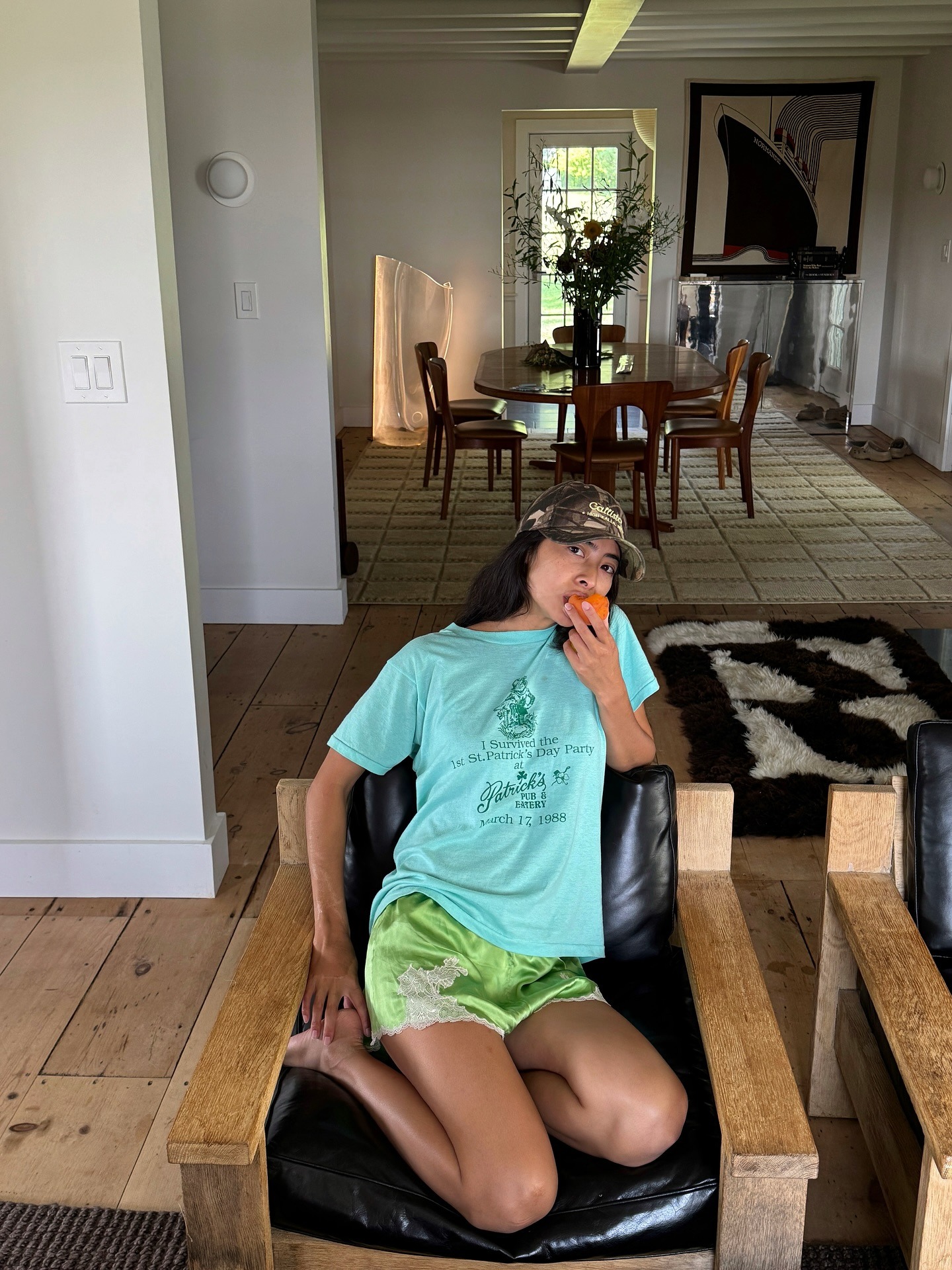 Influencer wearing an aqua T-shirt and green satin lace-trim shorts.