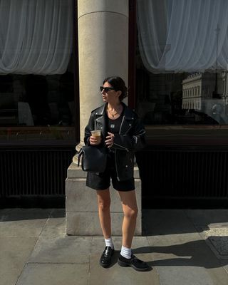 @francescasaffari wearing black denim shorts with a leather jacket and loafers