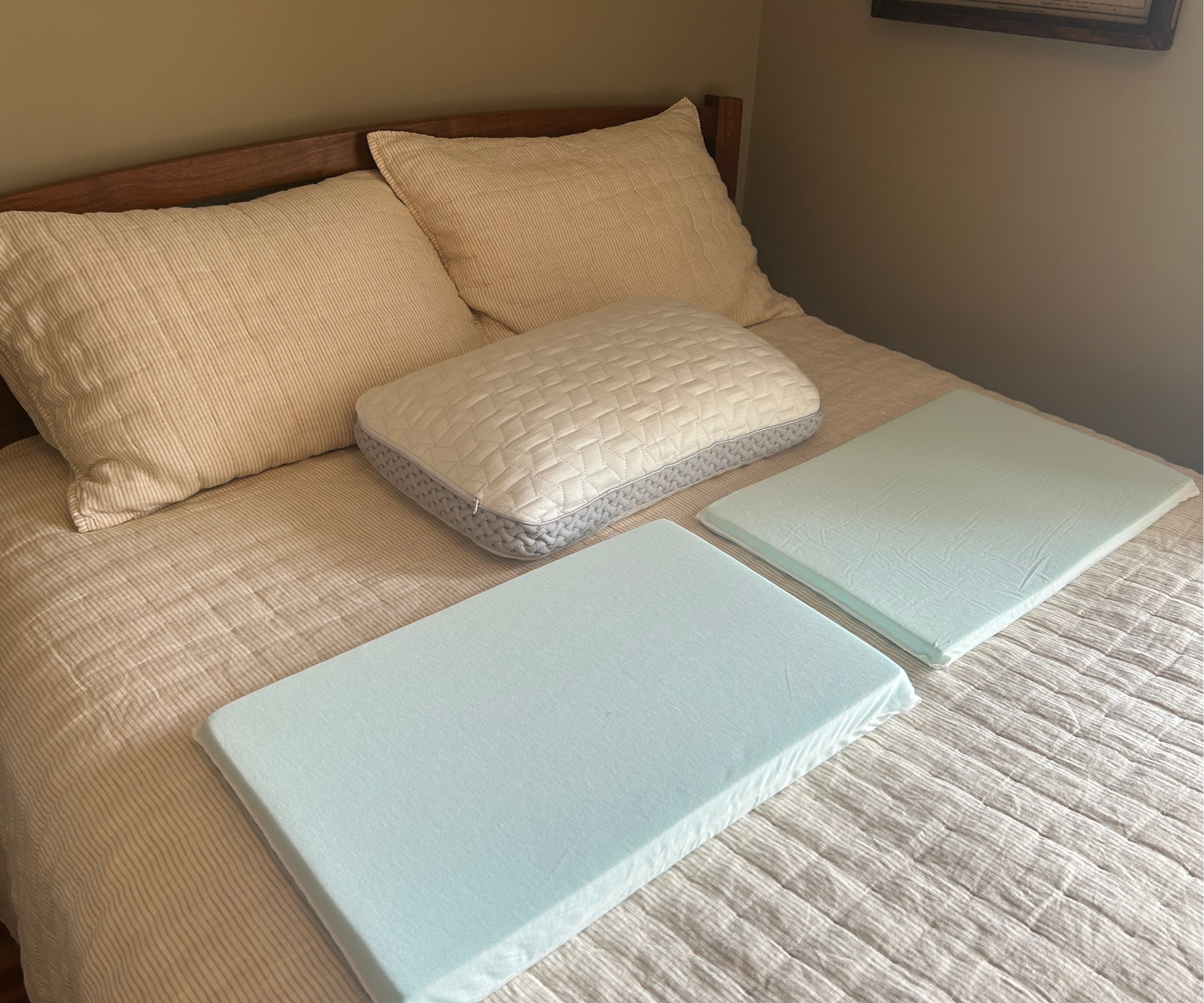 a bed with three pillows on top of it and two memory foam pillow inserts