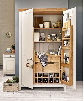cream coloured kitchen larder full of kitchen items in a spacious kitchen with grey walls