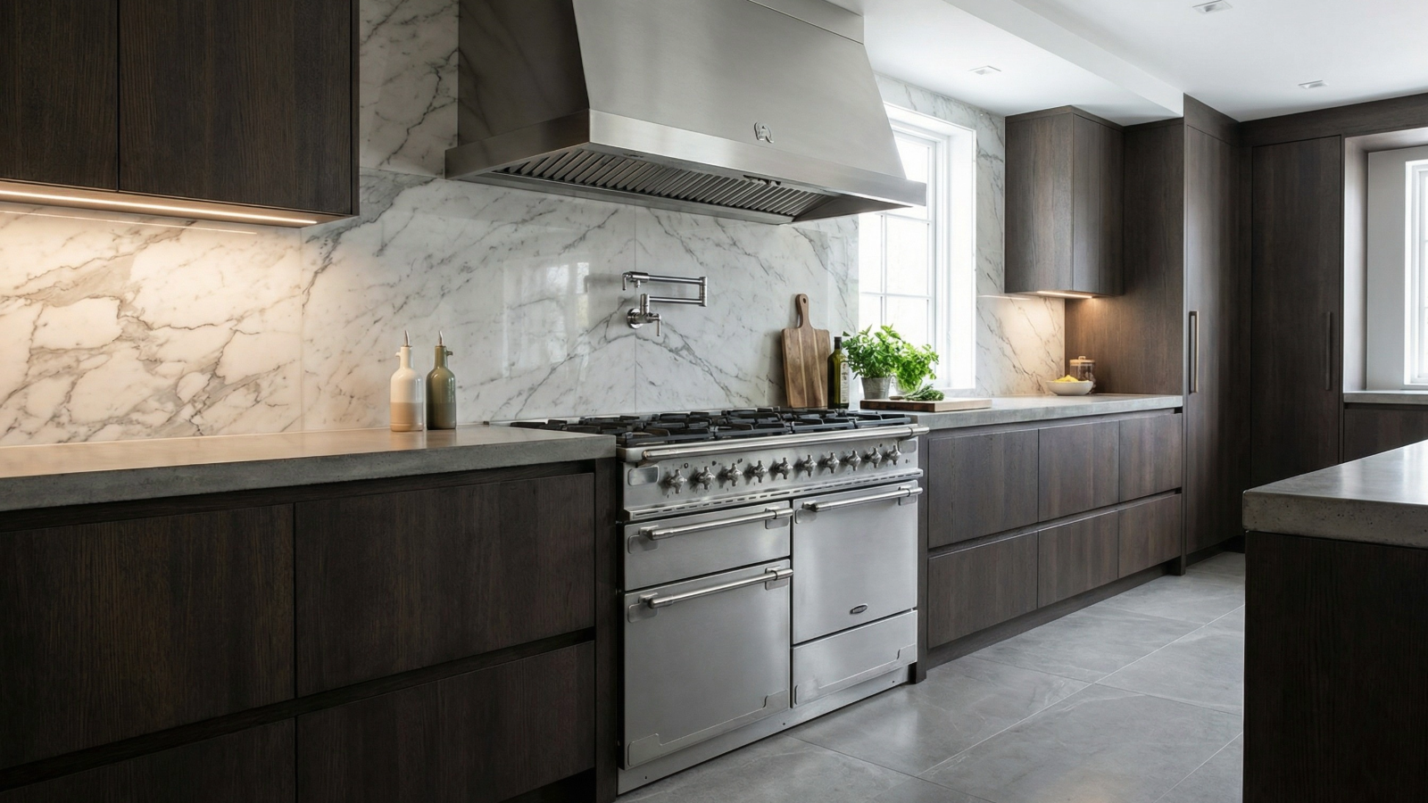 Silver range cooker in modern kitchen with marble splashback and wooden cabinets