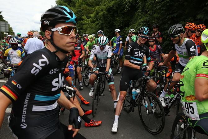 Riders wait at the side of the road after being neutralized during RideLondon Classic