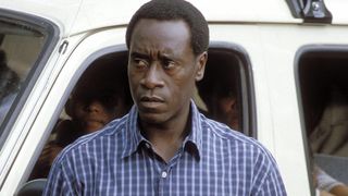Don Cheadle stands in front of a van in Hotel Rwanda