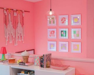 Kitchen with bright pink walls 3x3 white framed colorful prints and large macrame wall decor in white, pink and orange
