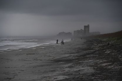 People bike on Atlantic Beach in Florida on Wednesday.