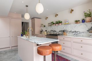 pink kitchen with white pendant lights and open shelving